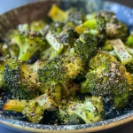 Close-up side view of crispy broccoli cooked in an air fryer.