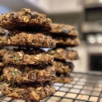 A close-up side view of chocolate chip kale cookies with a golden-brown exterior and visible chocolate chips.