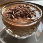 Close-up side view of a rich chocolate crème aux chocolat in a glass dish.