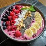 Close-up view of a vibrant smoothie bowl topped with fresh fruits and chia seeds.