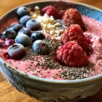 Smoothie bowl topped with fresh berries and sliced courgette.