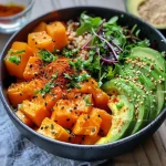 Close-up of a Buddha bowl featuring spiced chickpeas, colorful vegetables, and quinoa.
